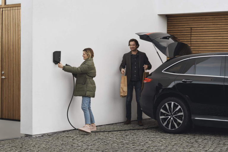 Couple charging their black electric car with an untethered charger at home